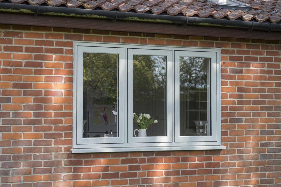 Residence 7 flush casement window in a light grey finish on a brick home