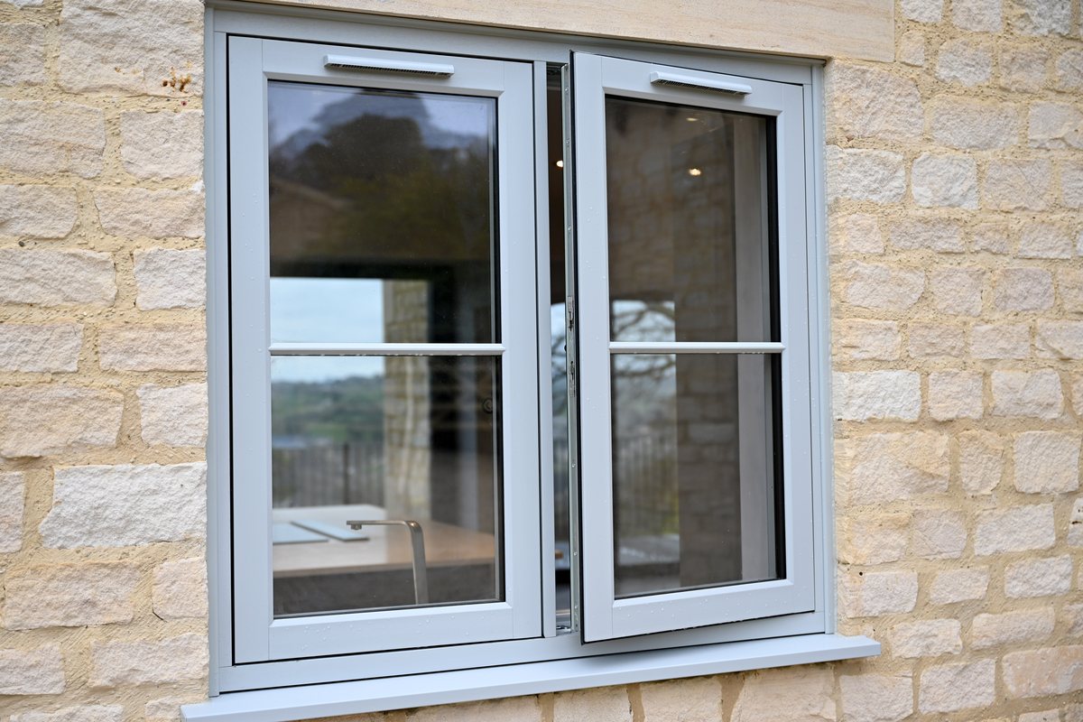 Residence 9 Painswick flush casement window open on a stone home