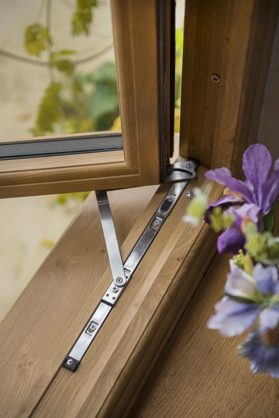 Close-up of a timber-look flush window detail with hinge hardware